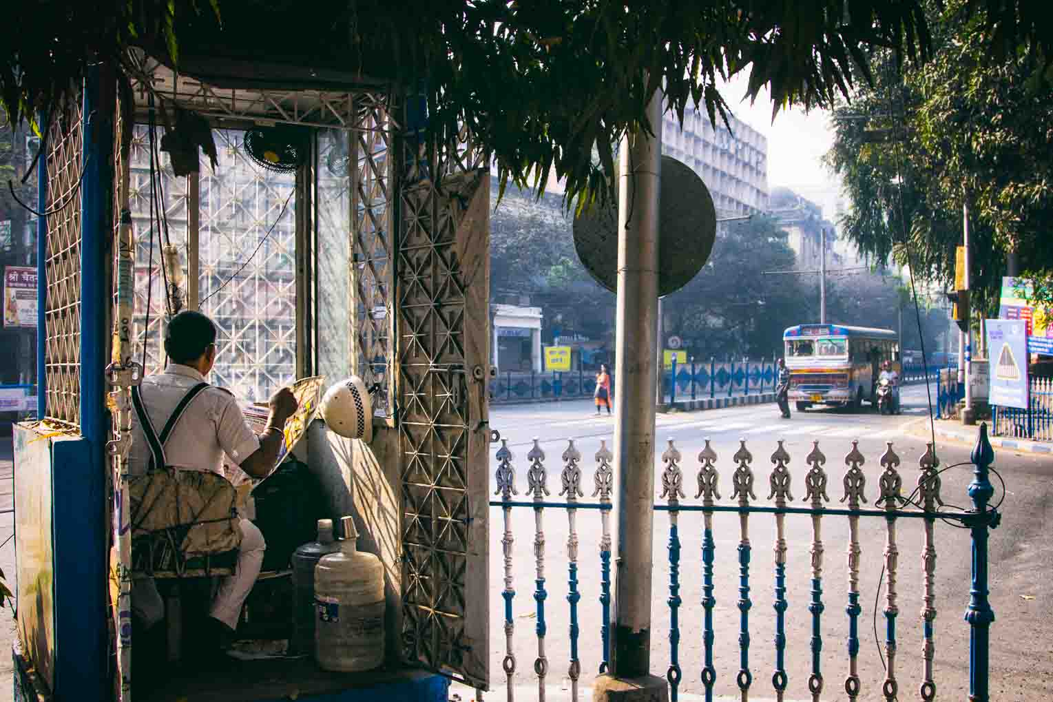 Vendor inside a small streetside kiosk early morning