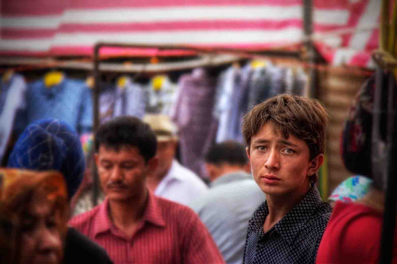 Light-haired boy with arresting blue eyes among the market crowd