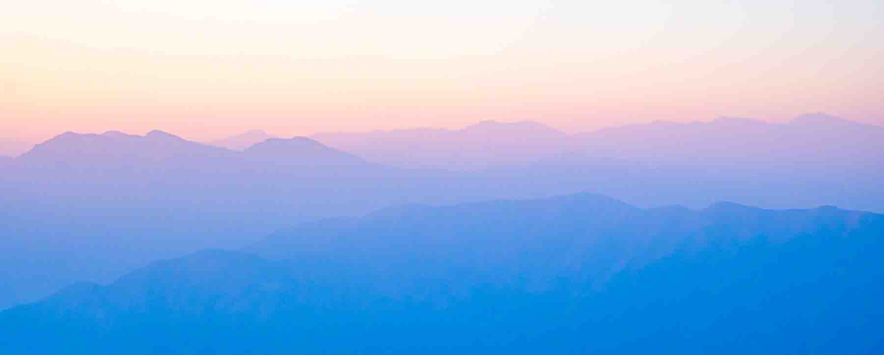 Layered mountain ridges receding into dusk
