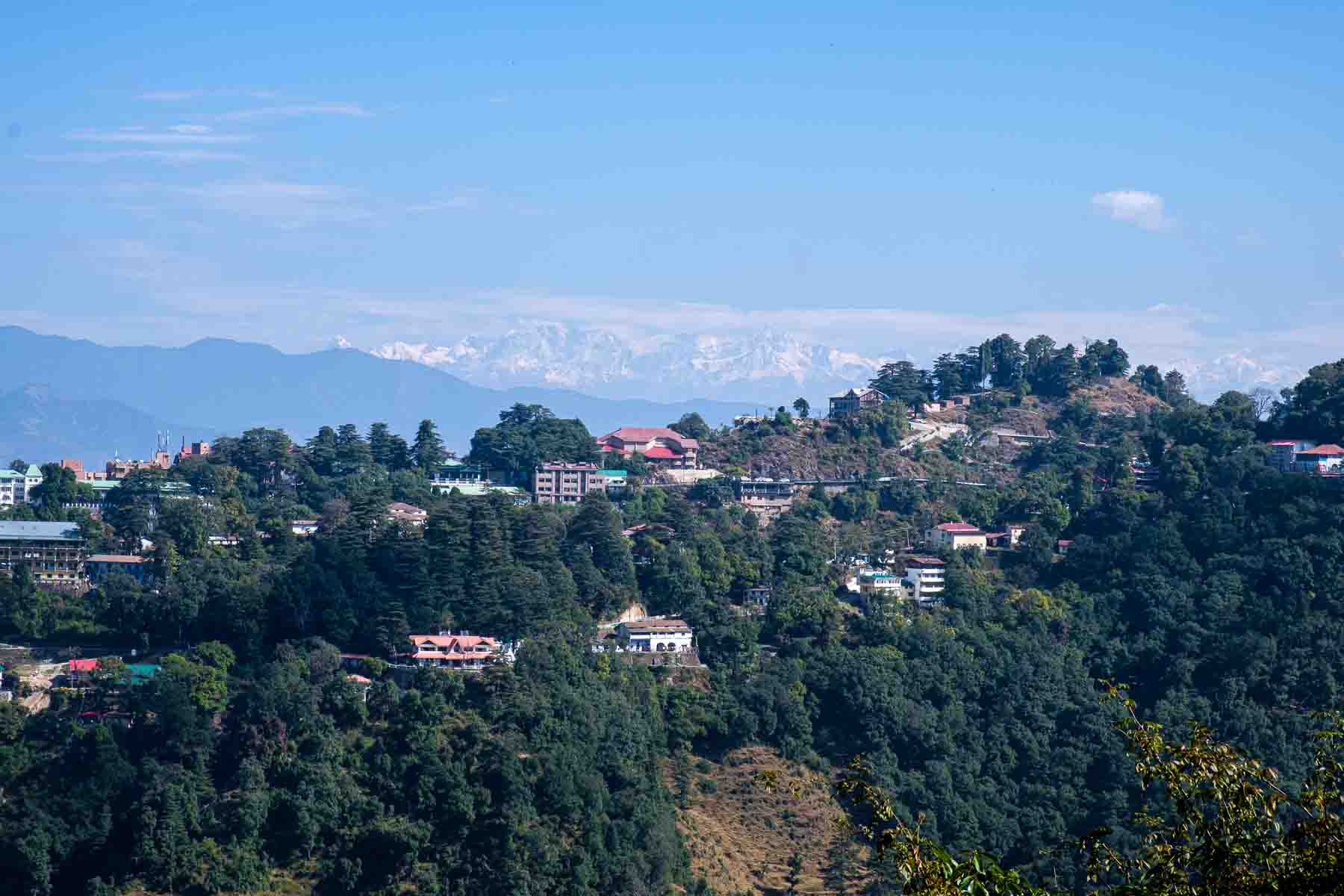 Hill town spread out below distant snow peaks